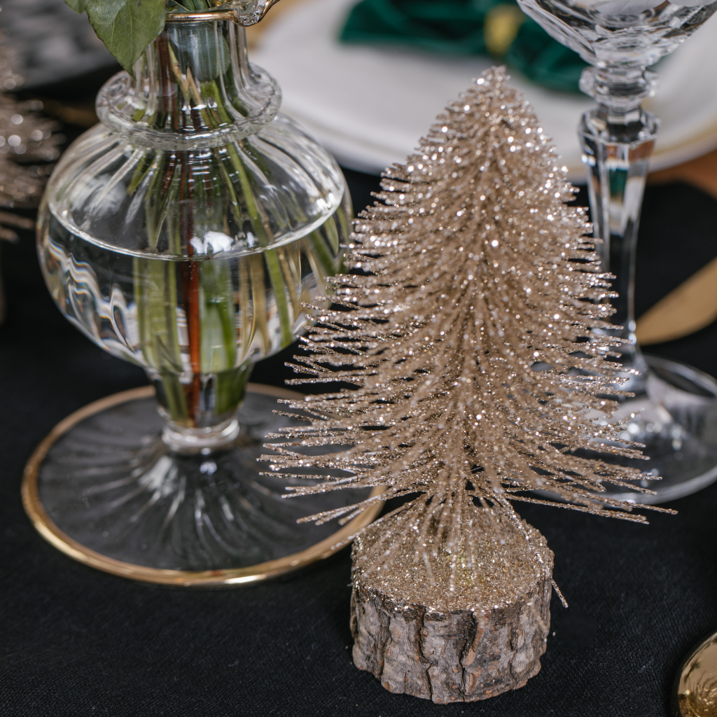 Gold glitter brush tree decoration on black linen table runner