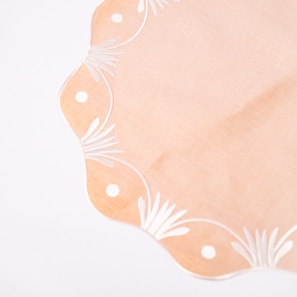 Pale pink embroidered placemat with scalloped edge