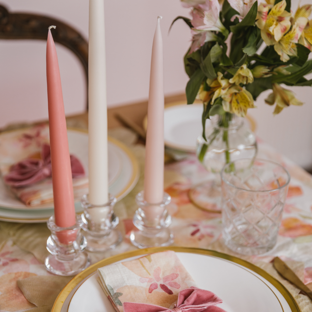 The Peaches and Cream place setting with pink water colour table runner, three clear glass tulip candle holders and three pink taper dinner candles 