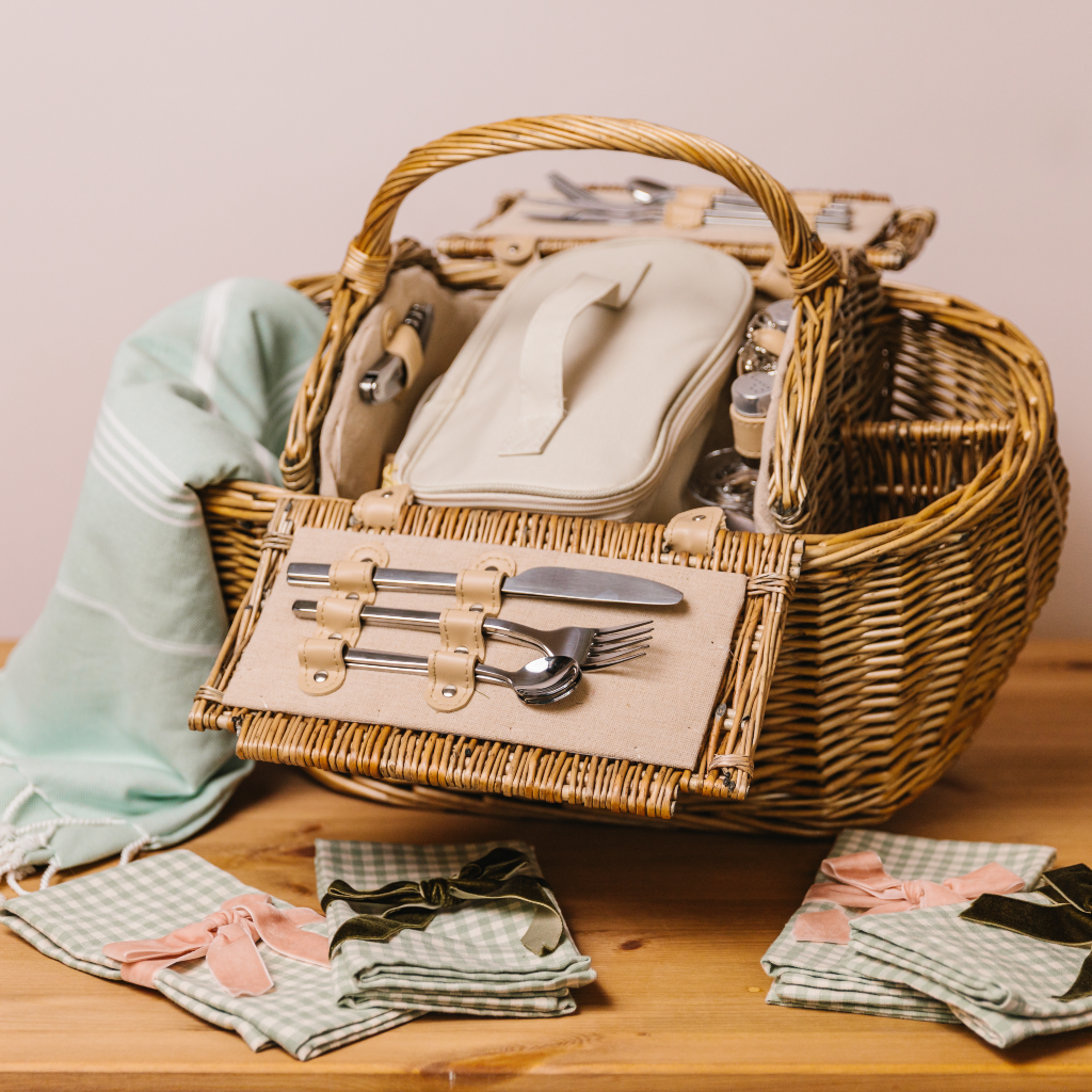 Fully fitted picnic basket with mint green hamman throw, mint and cream gingham napkins and luxurious velvet napkin bows. All displayed with cooler bag, cutlery, bottle opener, mini salt and pepper pots and wine glasses