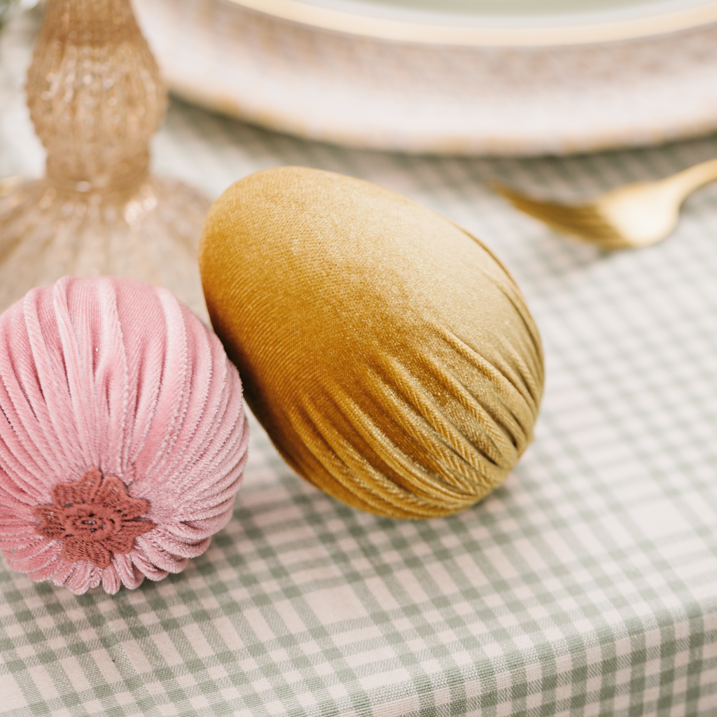 Large soft gold velvet handmade Easter egg balancing on a pink velvet Easter egg with applique trim