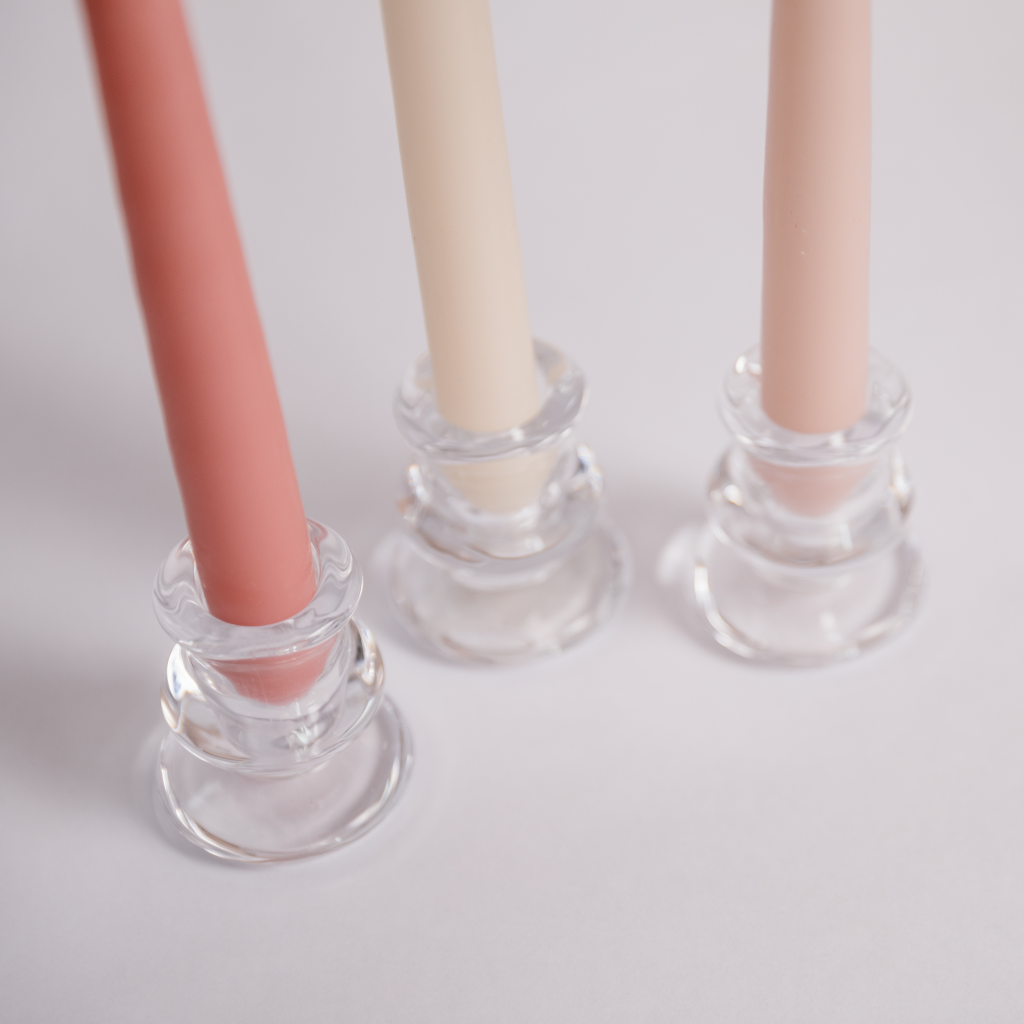 Clear glass tulip shaped candle holders with rose pink, powder pink and off white taper candles