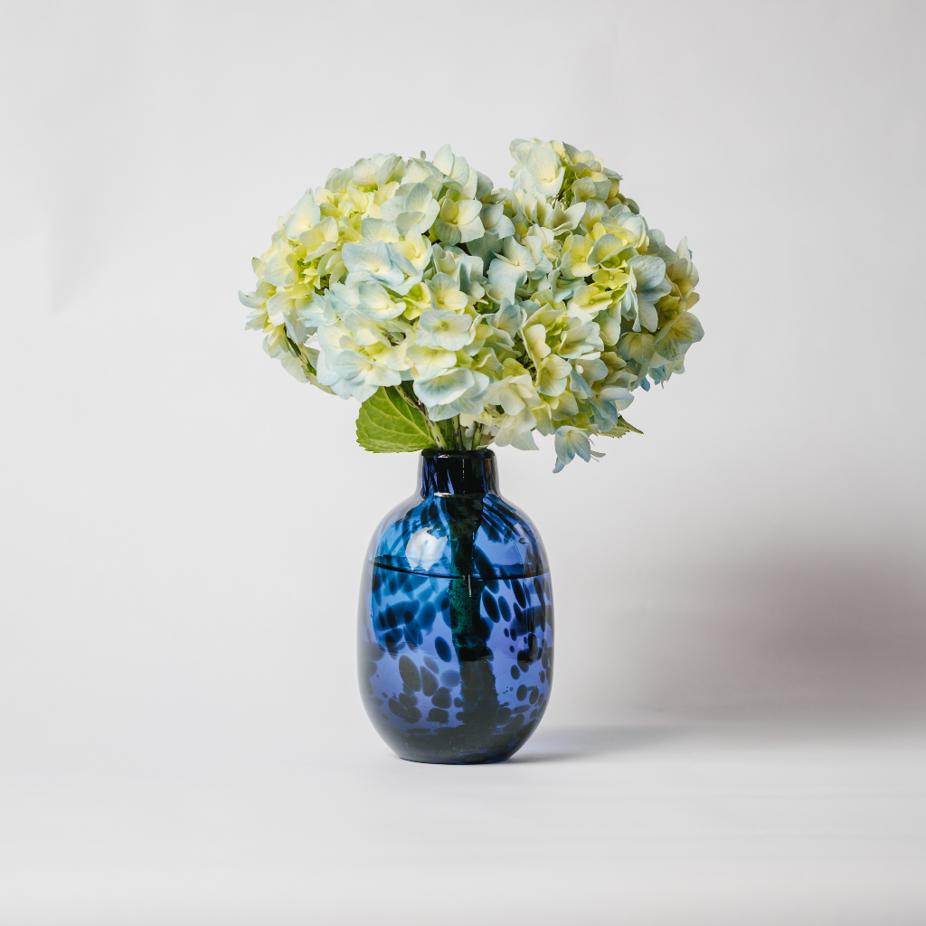 Royal blue leopard glass vase displaying blue and green hydrangea