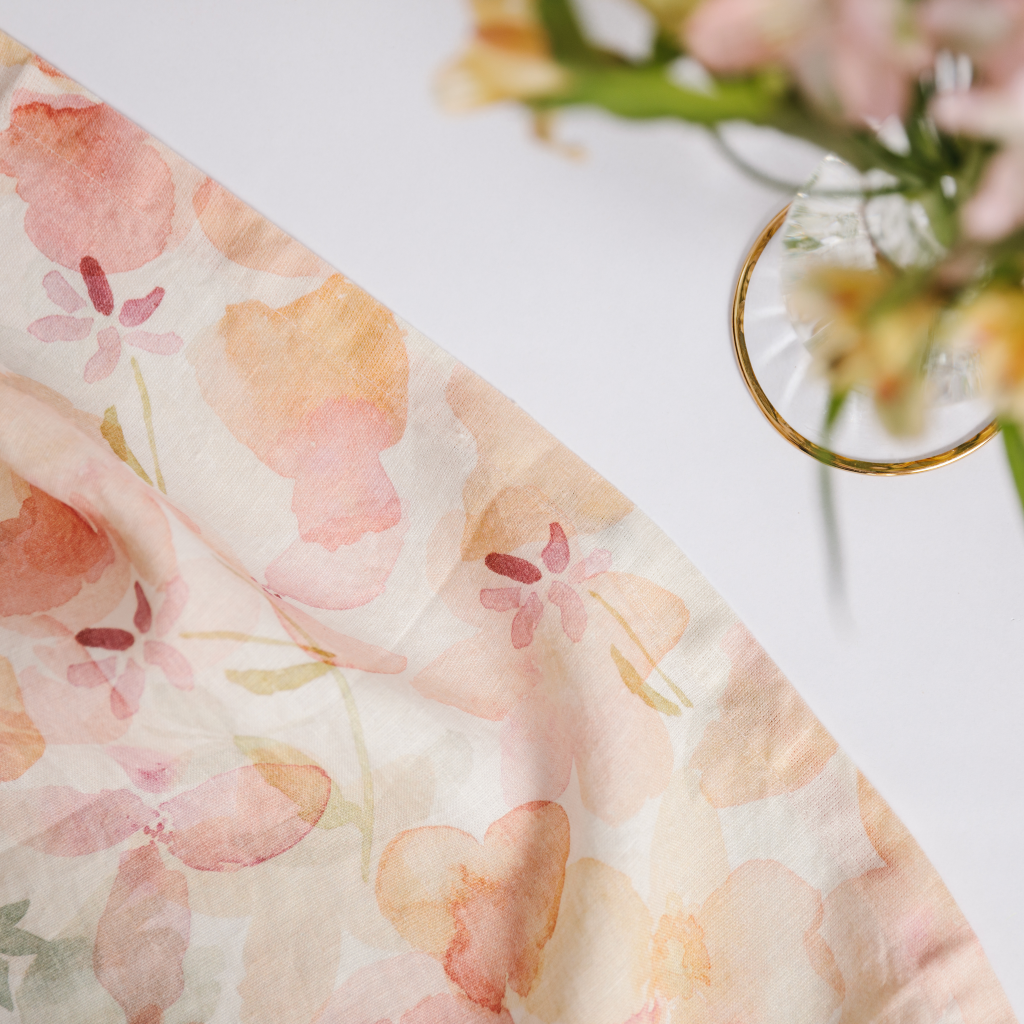 Close up of draped pink, peach and cream watercolour dappled pattern table runner made with 100% linen