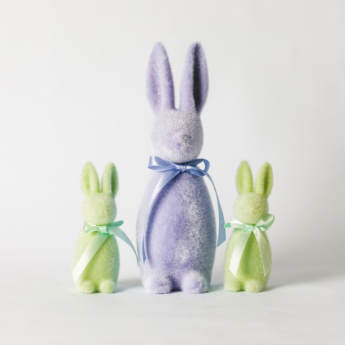 Large lilac flocked Easter bunny with ribbon tie standing centrally between two small flocked mint green Easter bunny twin decorations