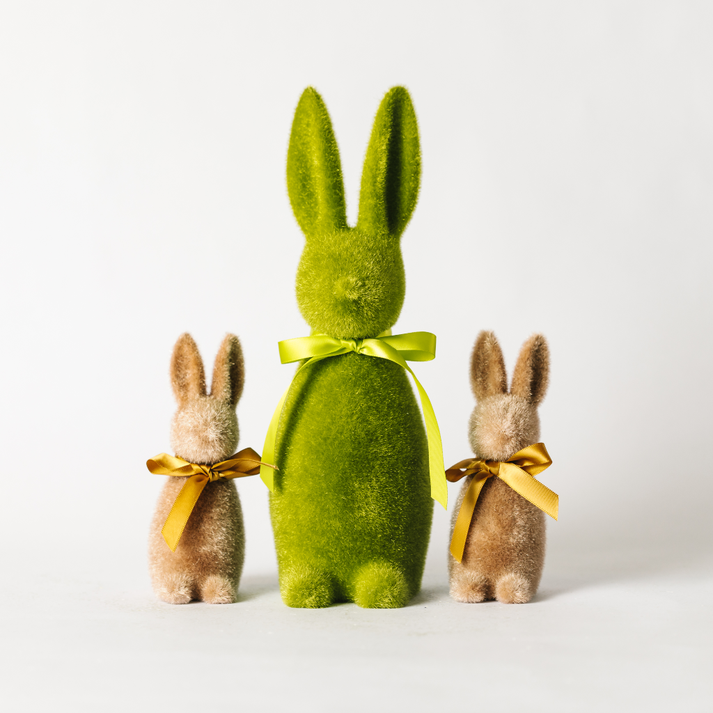 Large moss green flocked green bunny decoration sitting between two small brown flocked Easter bunny twins with light brown ribbon ties