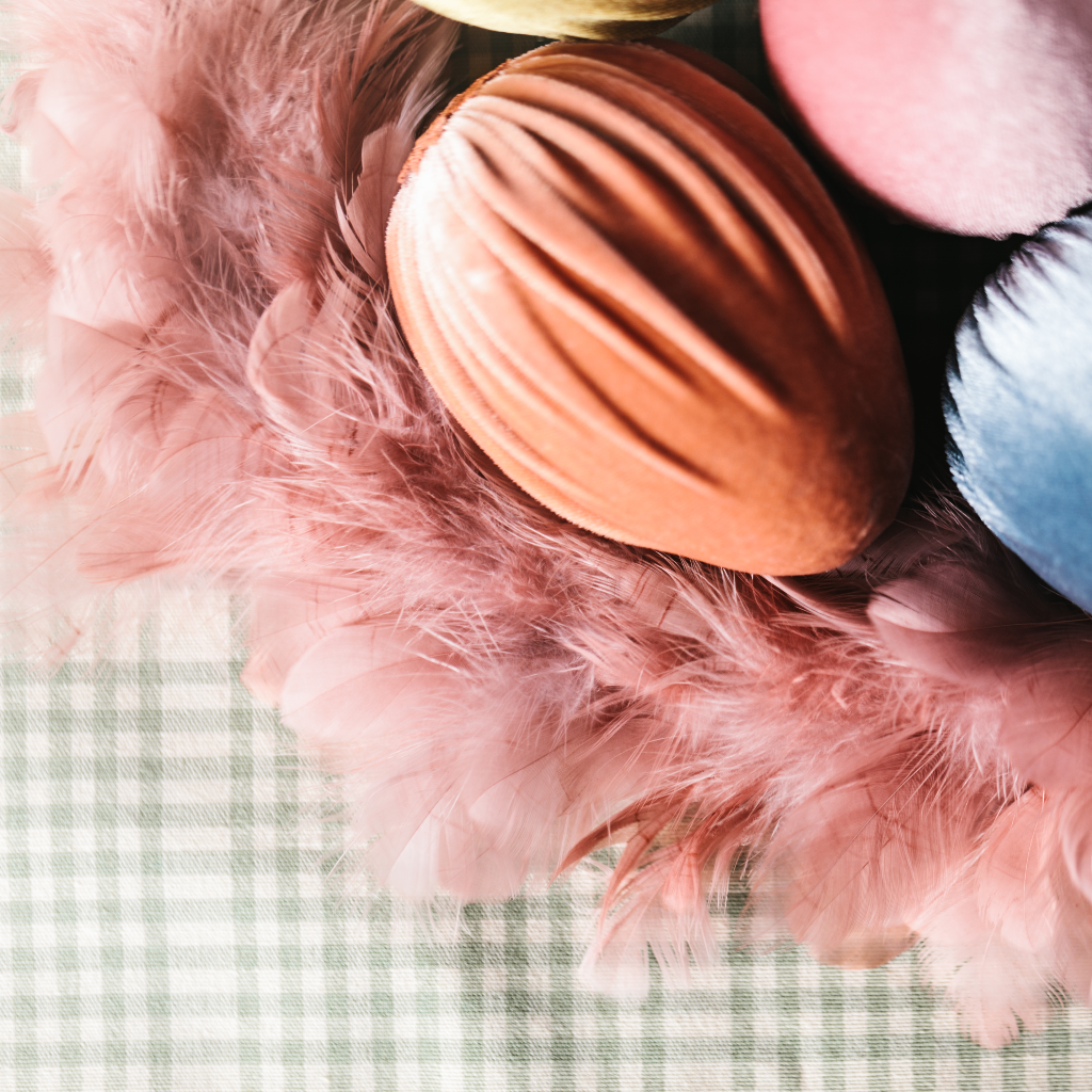 Close up of handmade peach velvet oversize Easter egg decoration within pink feather Easter wreath