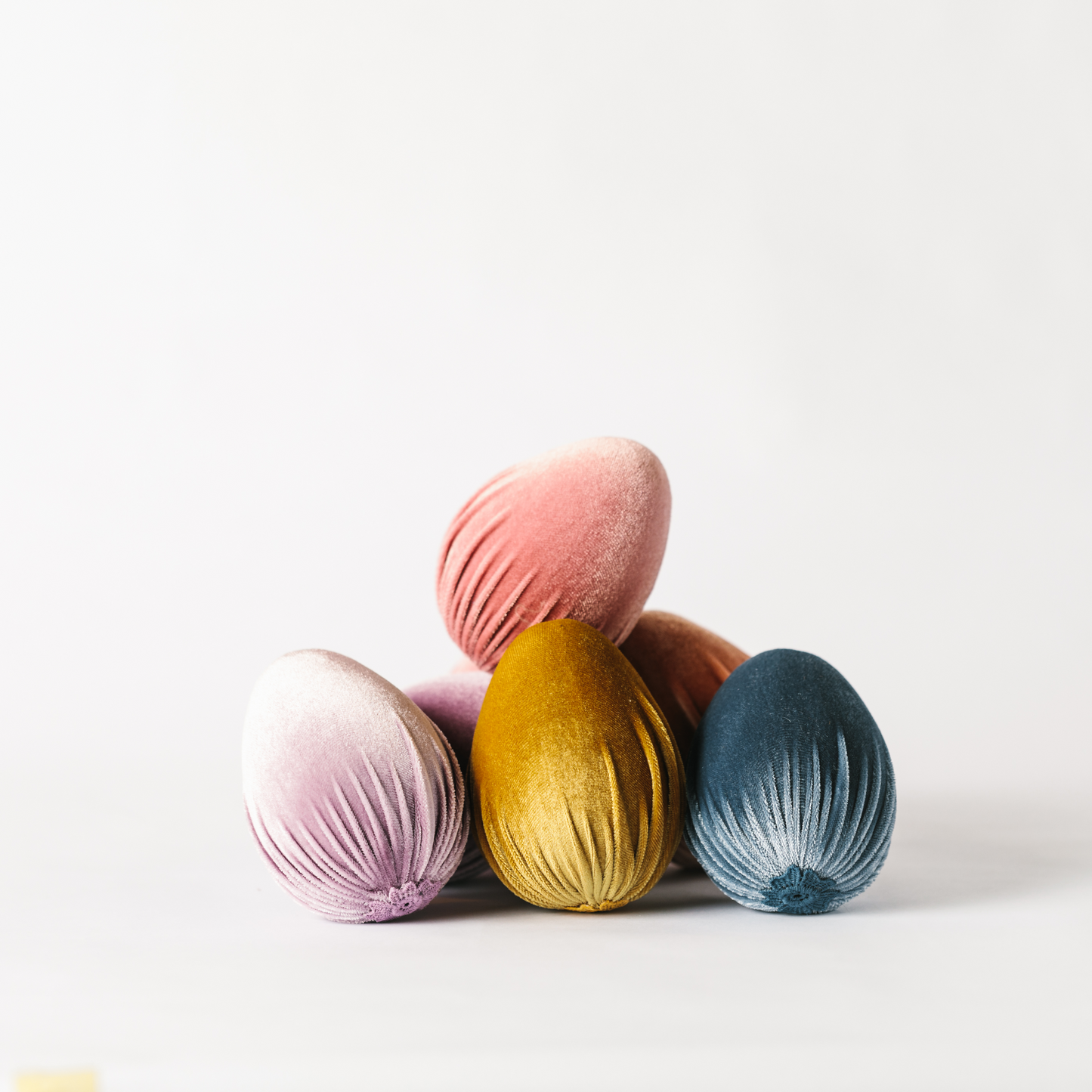 Pile of pastel velvet Easter egg decorations with applique detailing
