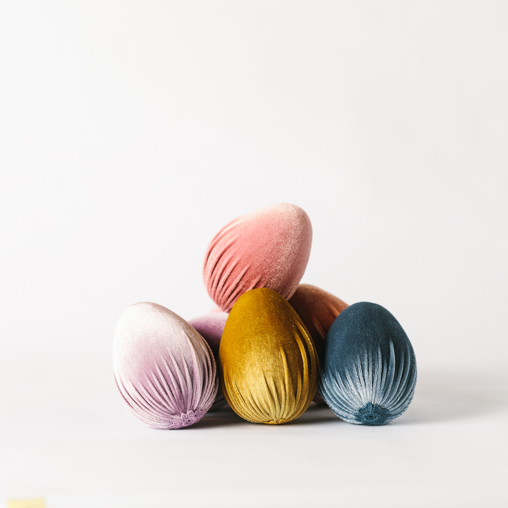 Pile of pastel velvet Easter egg decorations with applique detailing