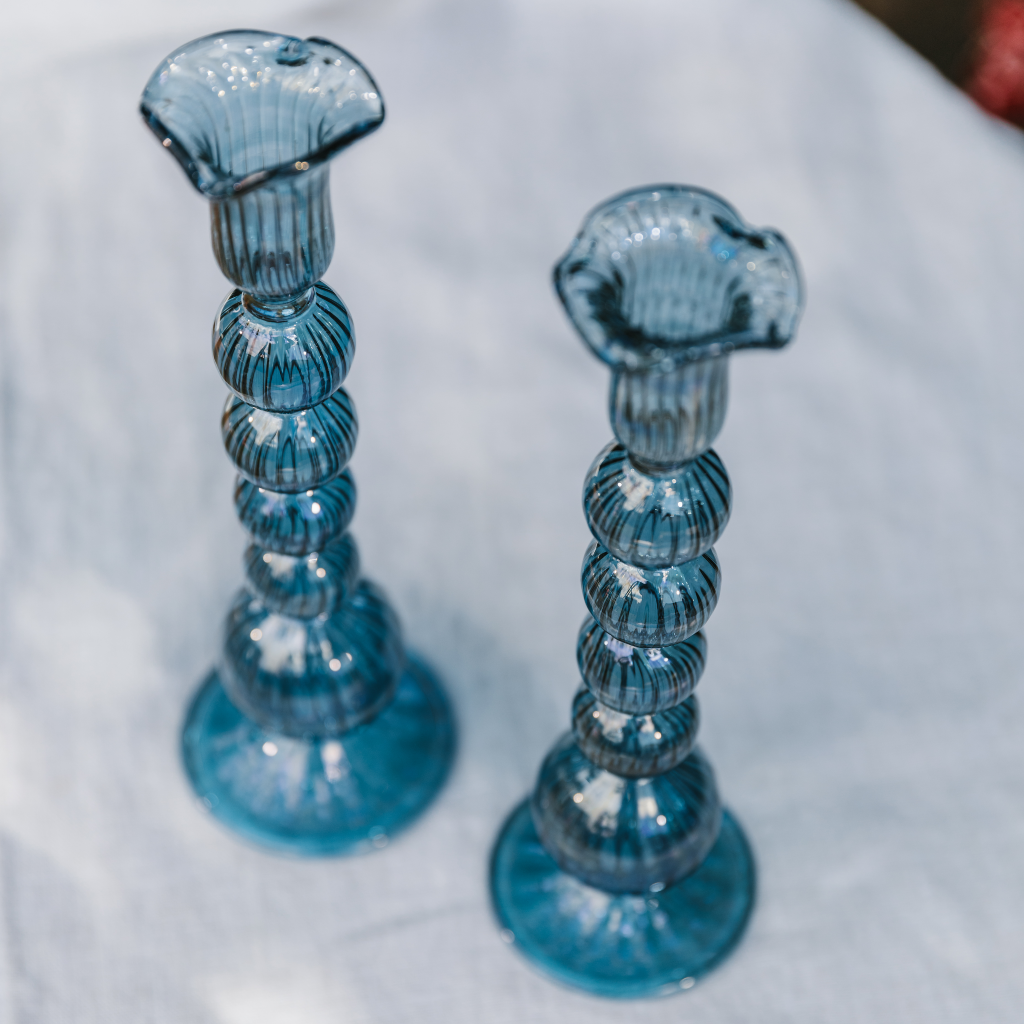 Top down view of blue glass candle holders with ruffled edge and orb detailing.