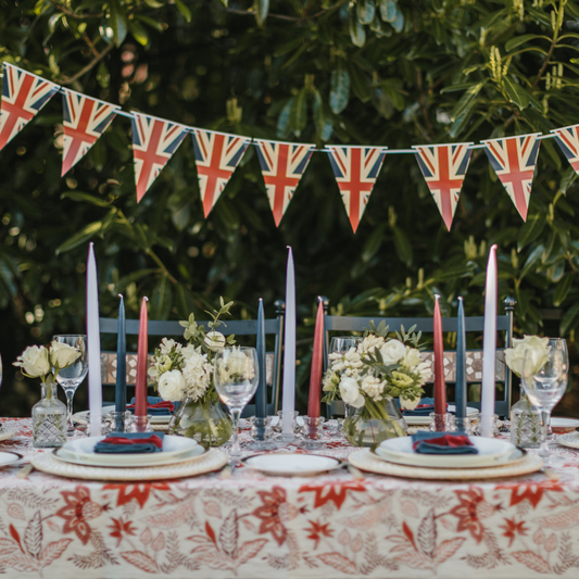 Diamond Jubilee Tablescape with union jack bunting, red, white and blue tapered candles and red patterned table linen