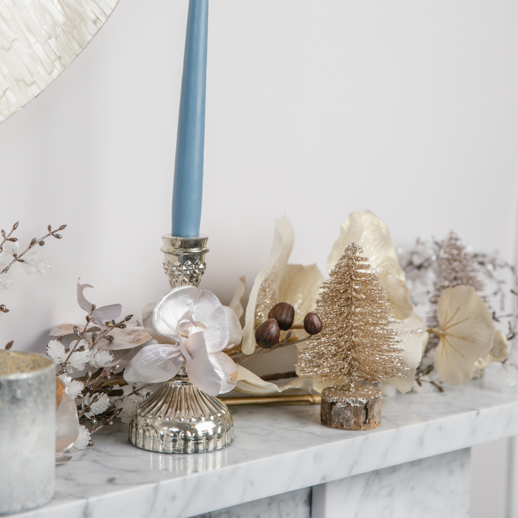 Mantlepiece with silver candle holder and gold brush tree decoration